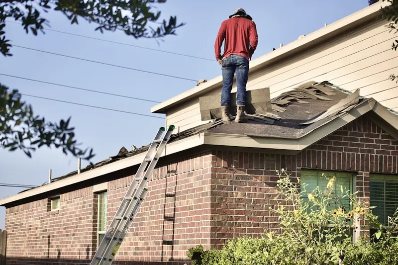 Professional roofer working on a residential roof in Tomlin